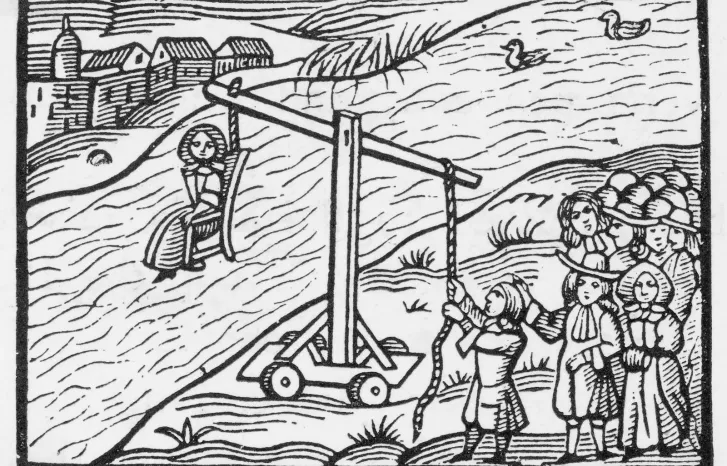 Sort-hvitt-tegning av en kvinne som blir dyppet i vann til offentlig skue ved hjelp av en "ducking" eller "cucking stool"