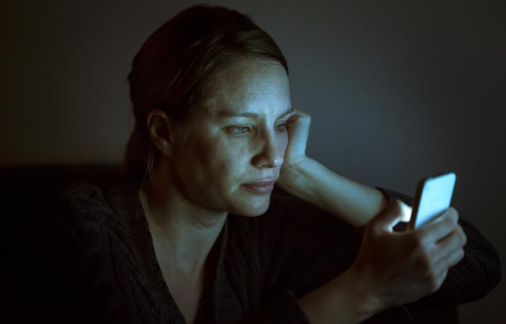 Kvinne ser på mobilen sin