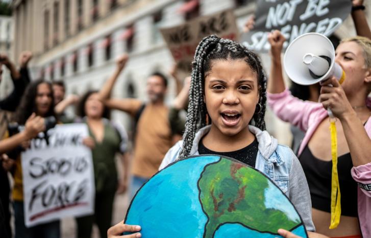 Jente holder bilde av jordkloden i klimademonstrasjon