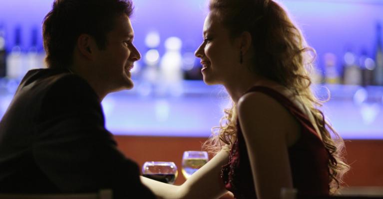 Ung mann og kvinne sitter i en bar