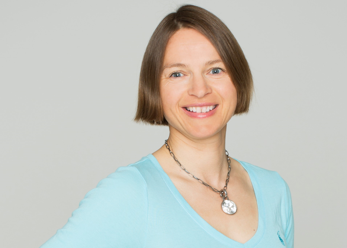 Kvinne i blå genser med ganske kort, brunt hår