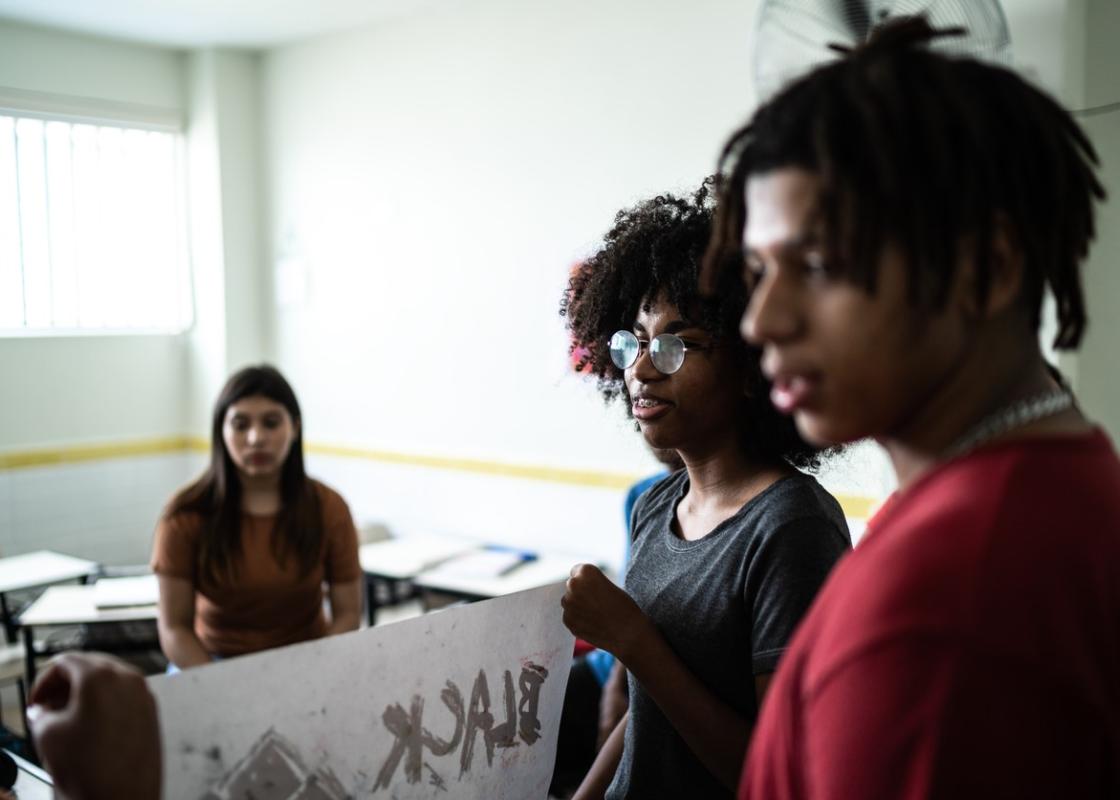 Tre brune ungdommer forbereder en antirasist-demonstrasjon