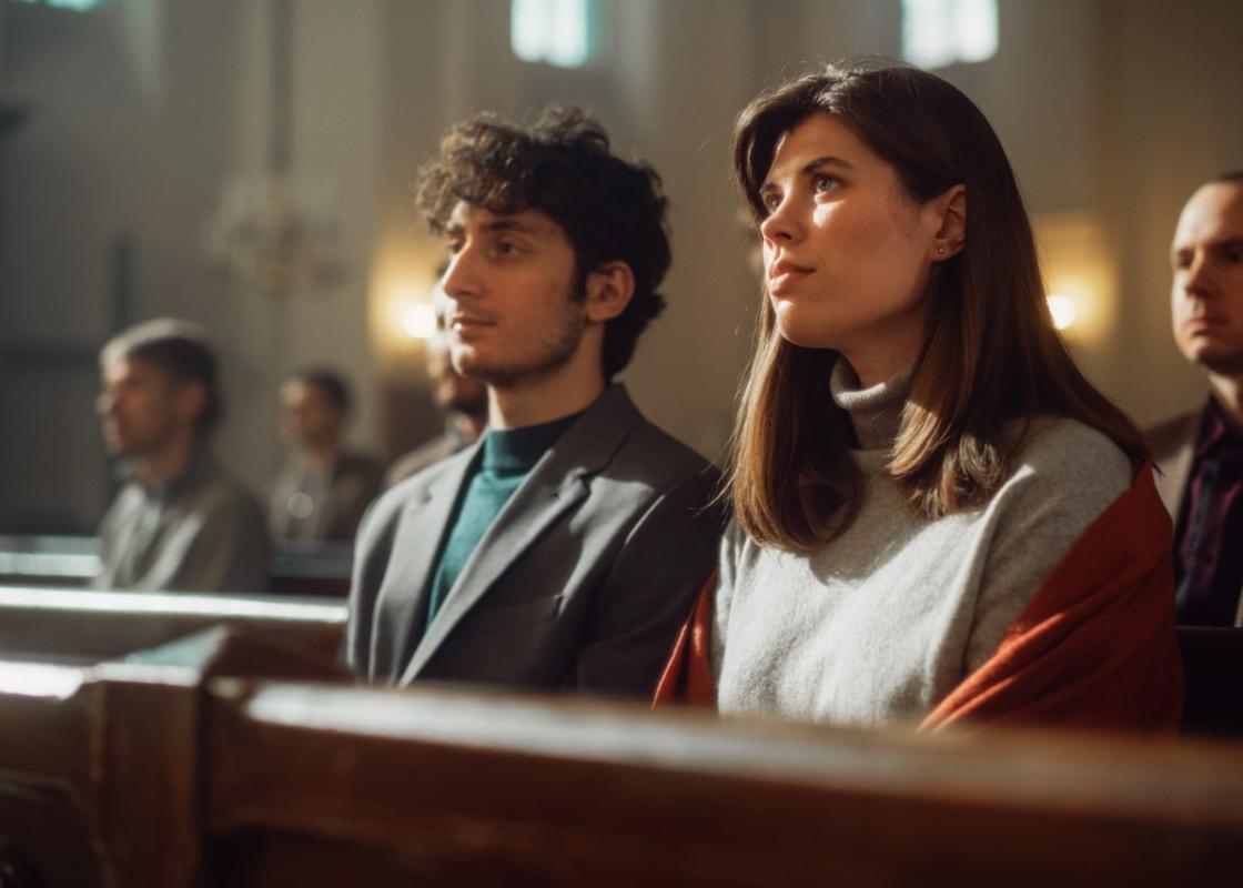 En ung mann og en ung kvinner sitter på kirkebenken 