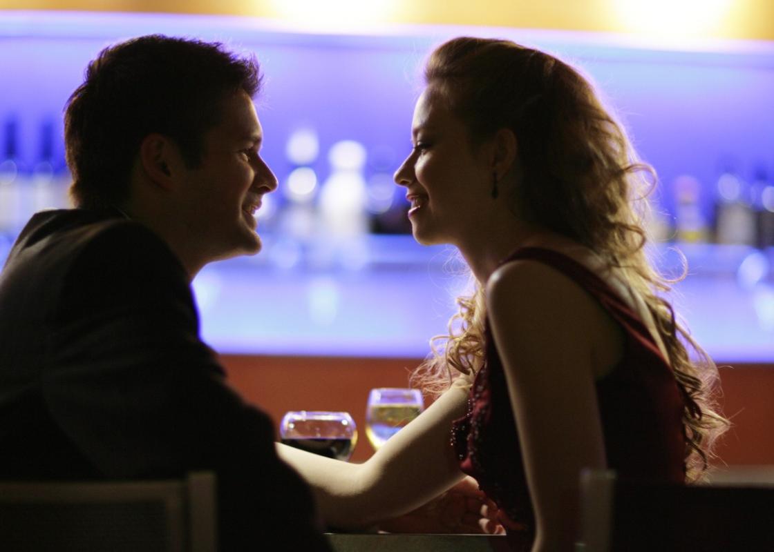 Ung mann og kvinne sitter i en bar