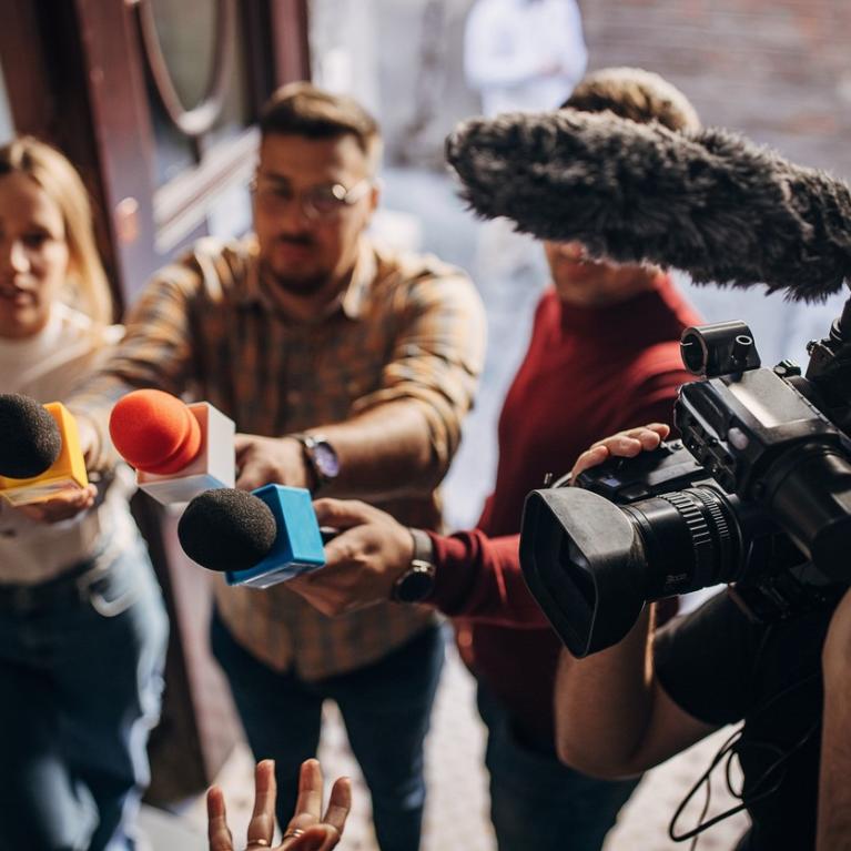 Journalister retter mikrofoner og kamera mot intervjuobjekt