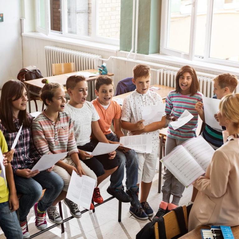 Lærer underviser en gruppe ungdommer i et klasserom i musikk