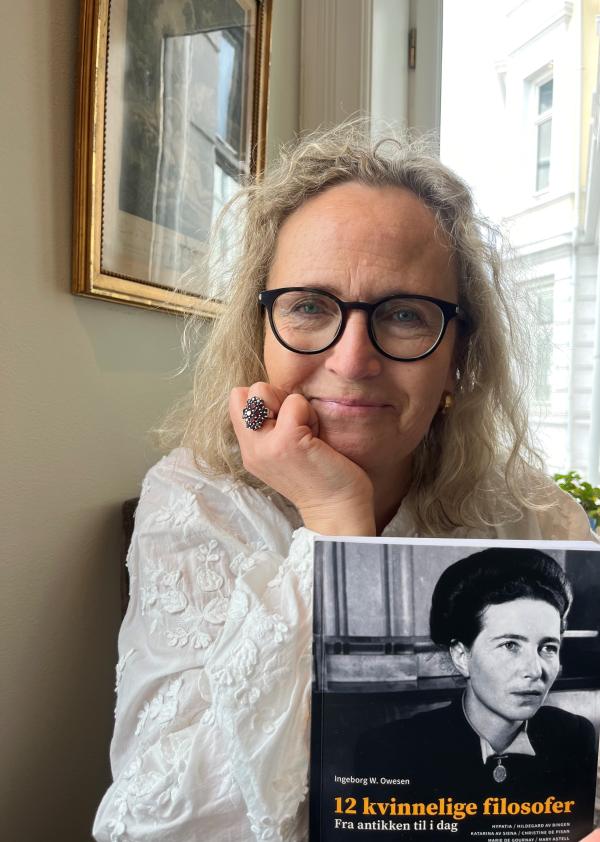 Portrettfoto av Ingeborg Owesen som holder sin nye bok om kvinnelige filosofer.